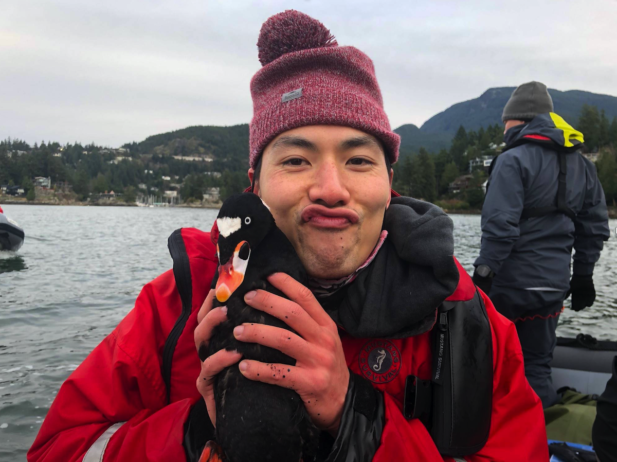 Andrew with a duck face, while holding a seaduck  in Howe Sound, British Columbia. <br>Surf Scoter (<i>Melanitta perspicillata</i>)