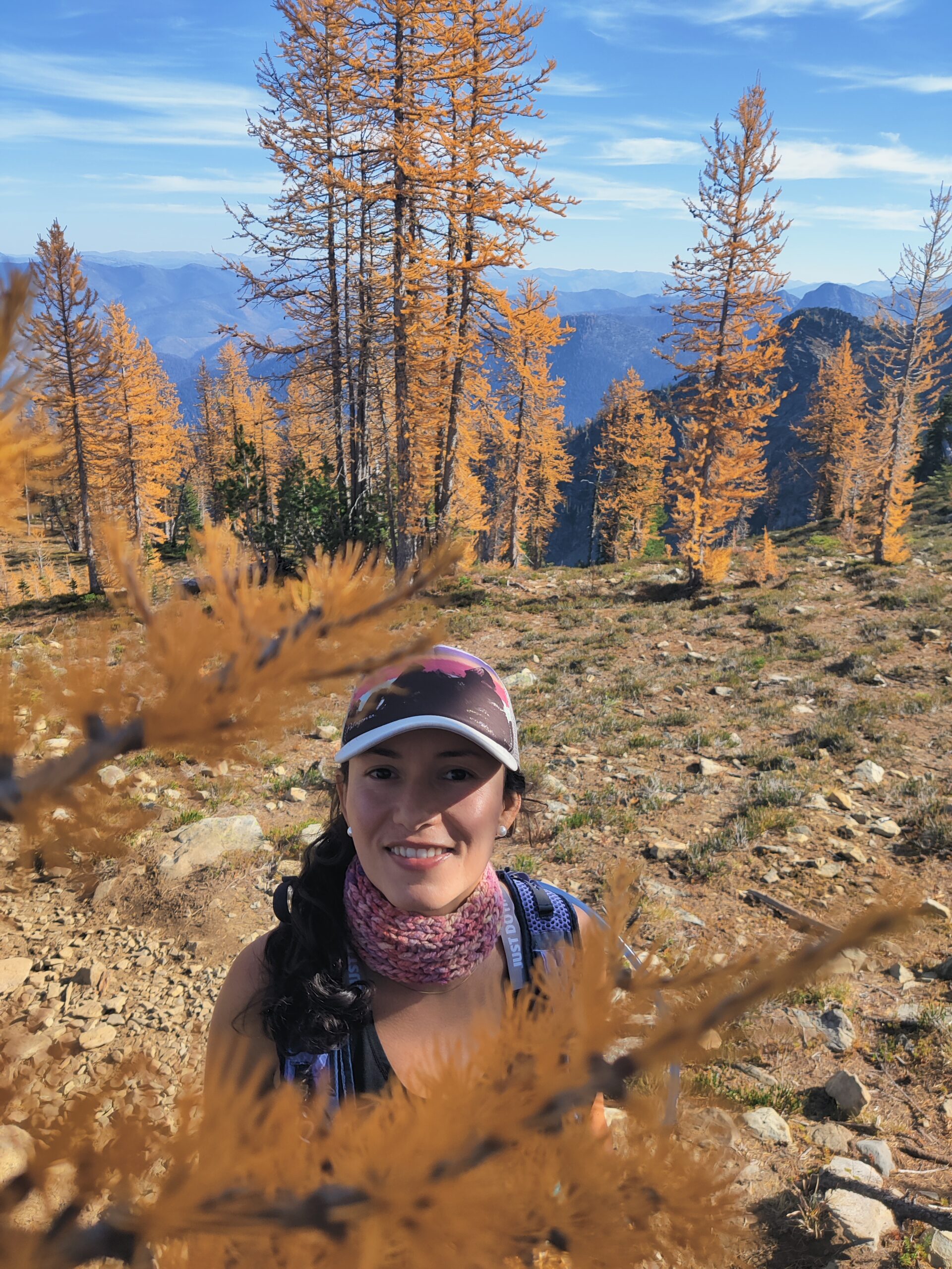 Woman hiking in autumn landscape surrounded by golden trees