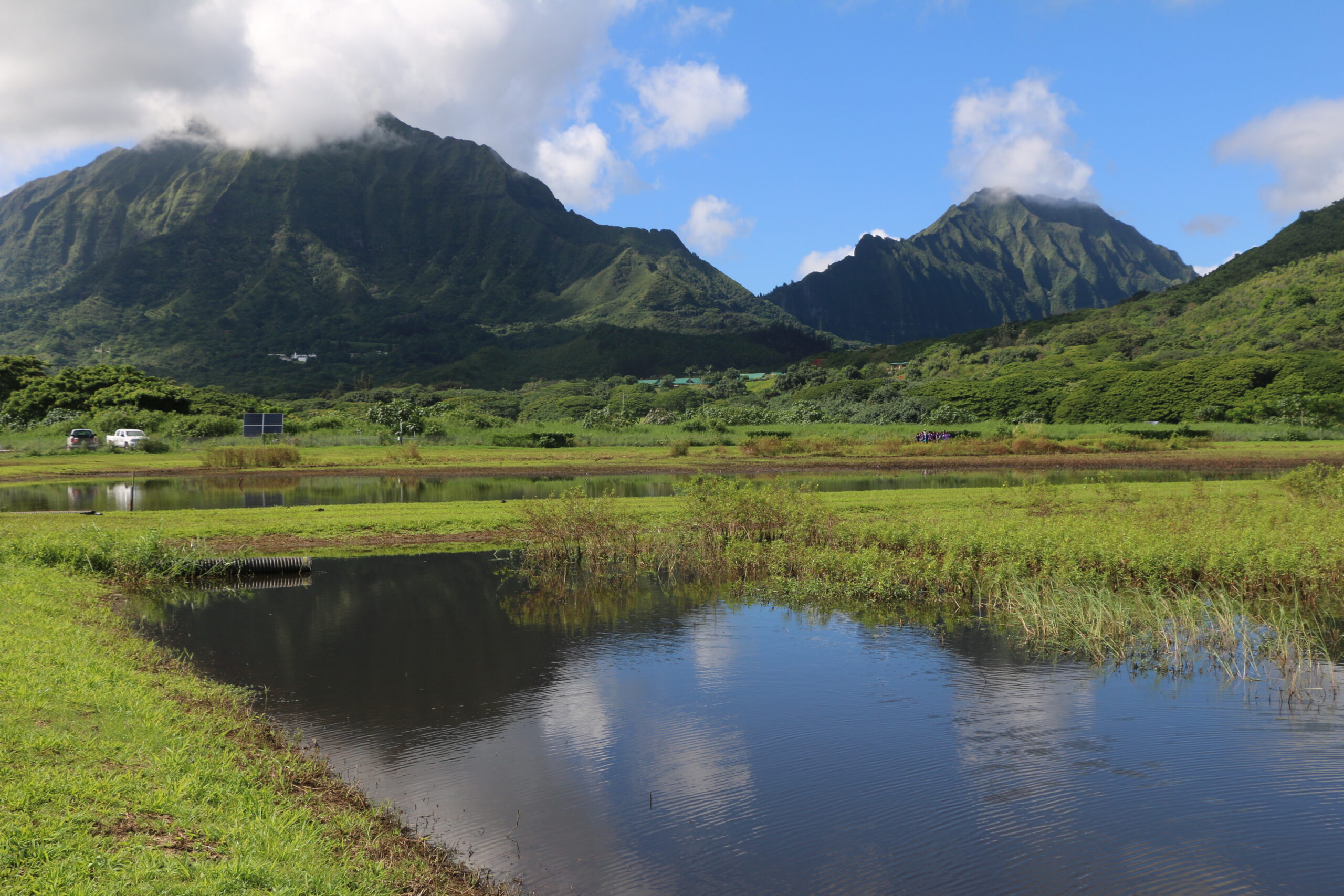 Scenic view of lush mountains and tranquil lake under blue sky