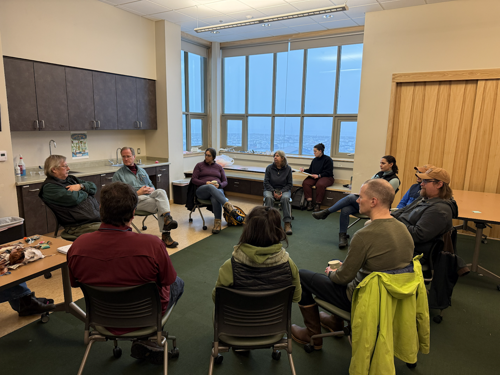 People sit in a circle and discuss at a meeting.