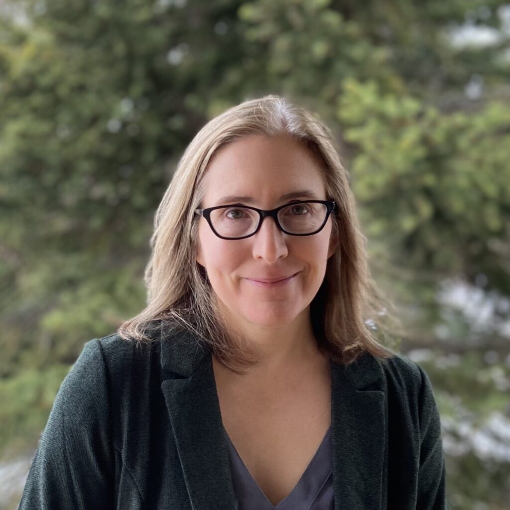 A headshot of a woman looking at the camera