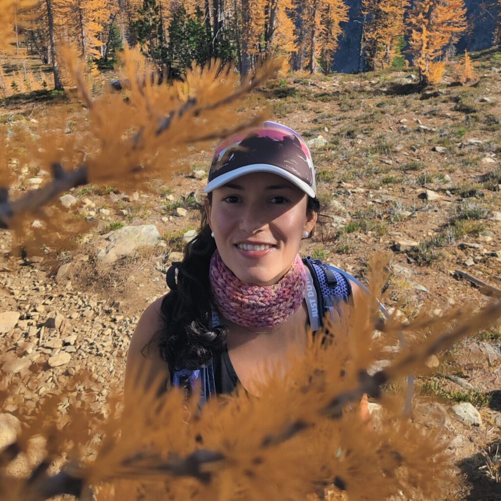 Woman hiking in autumn landscape surrounded by golden trees